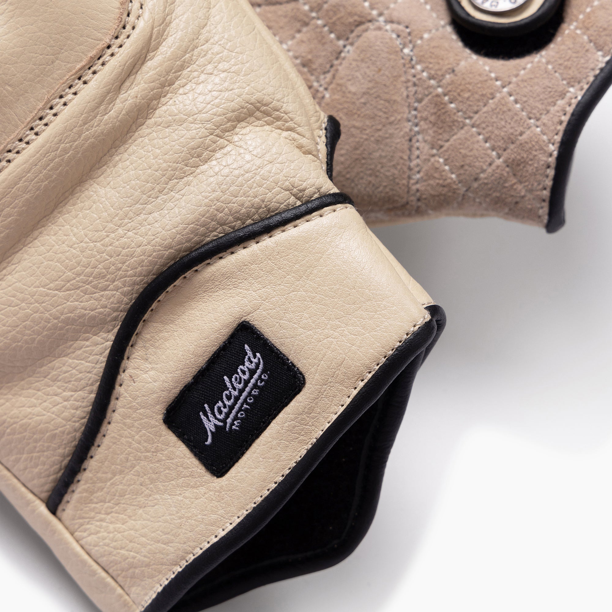 Beige leather motorcycle gloves with a brand logo on a light background