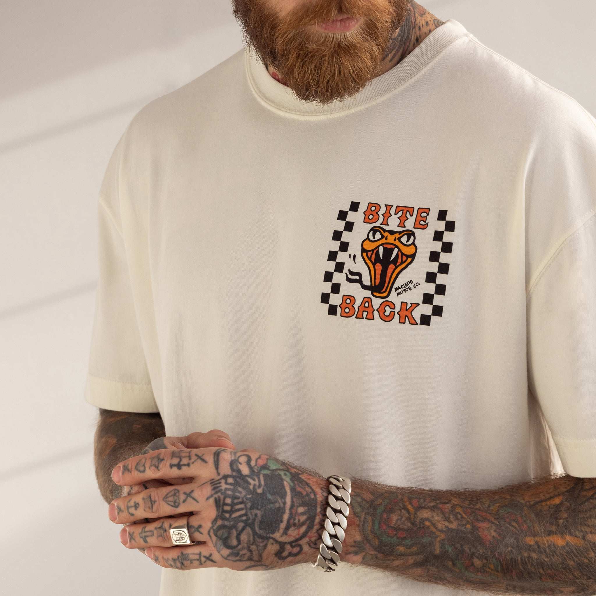 Person wearing a white sweatshirt with a graphic design featuring a tiger and text on a plain background