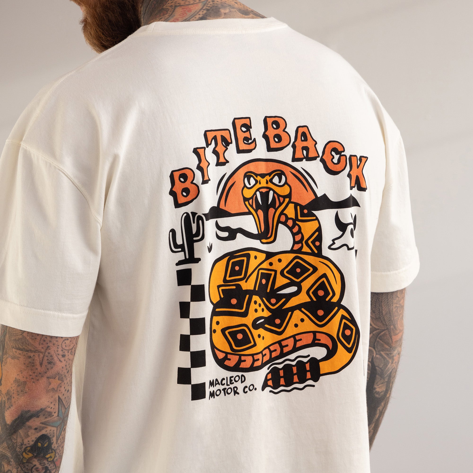 White t-shirt with a snake graphic and 'Bite Back' text on the back, worn by a person.