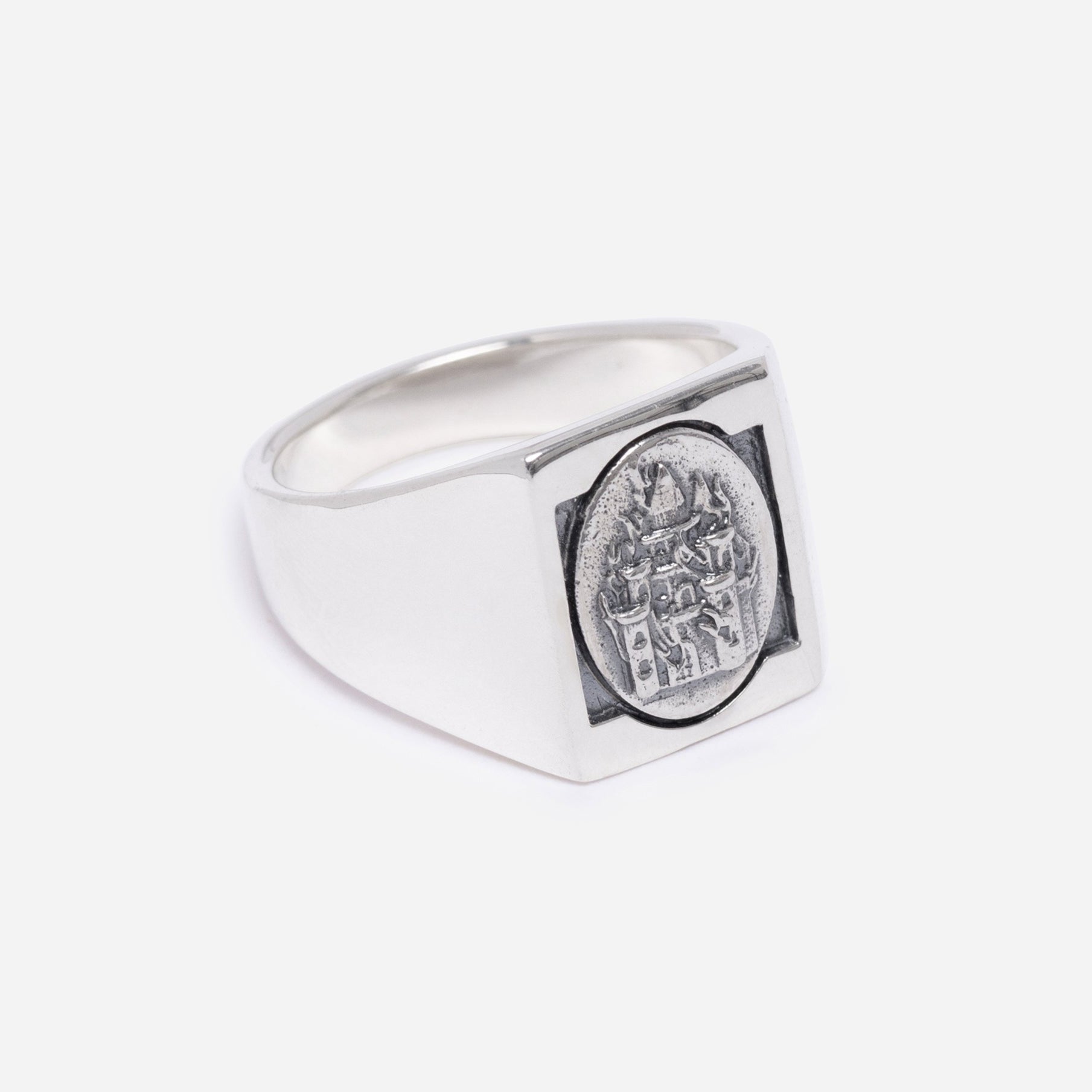 Silver ring with a engraved design on a light gray background