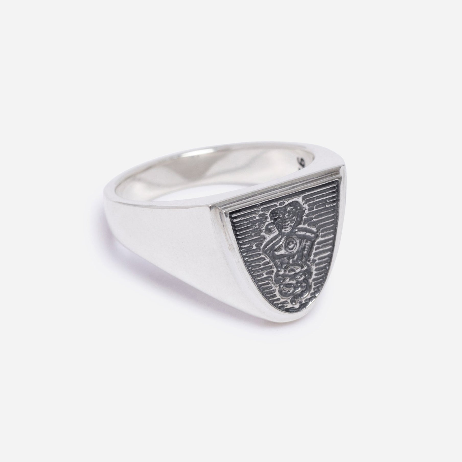 Silver ring with detailed design on a light gray background